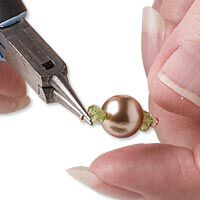 Pliers bending a loop in beaded wire